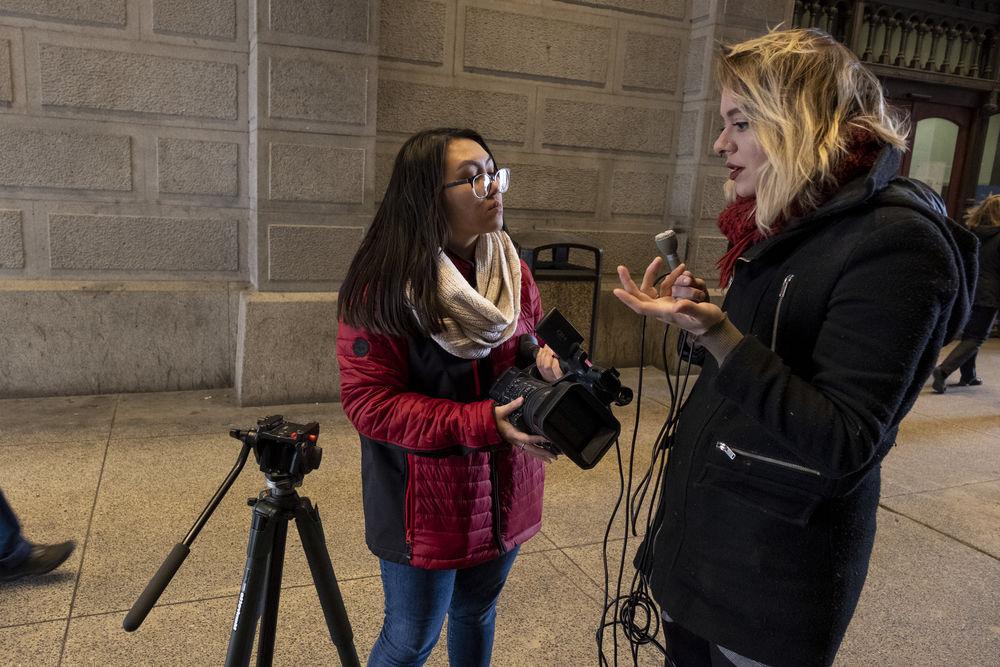 A student reporter talks with a source on the street.